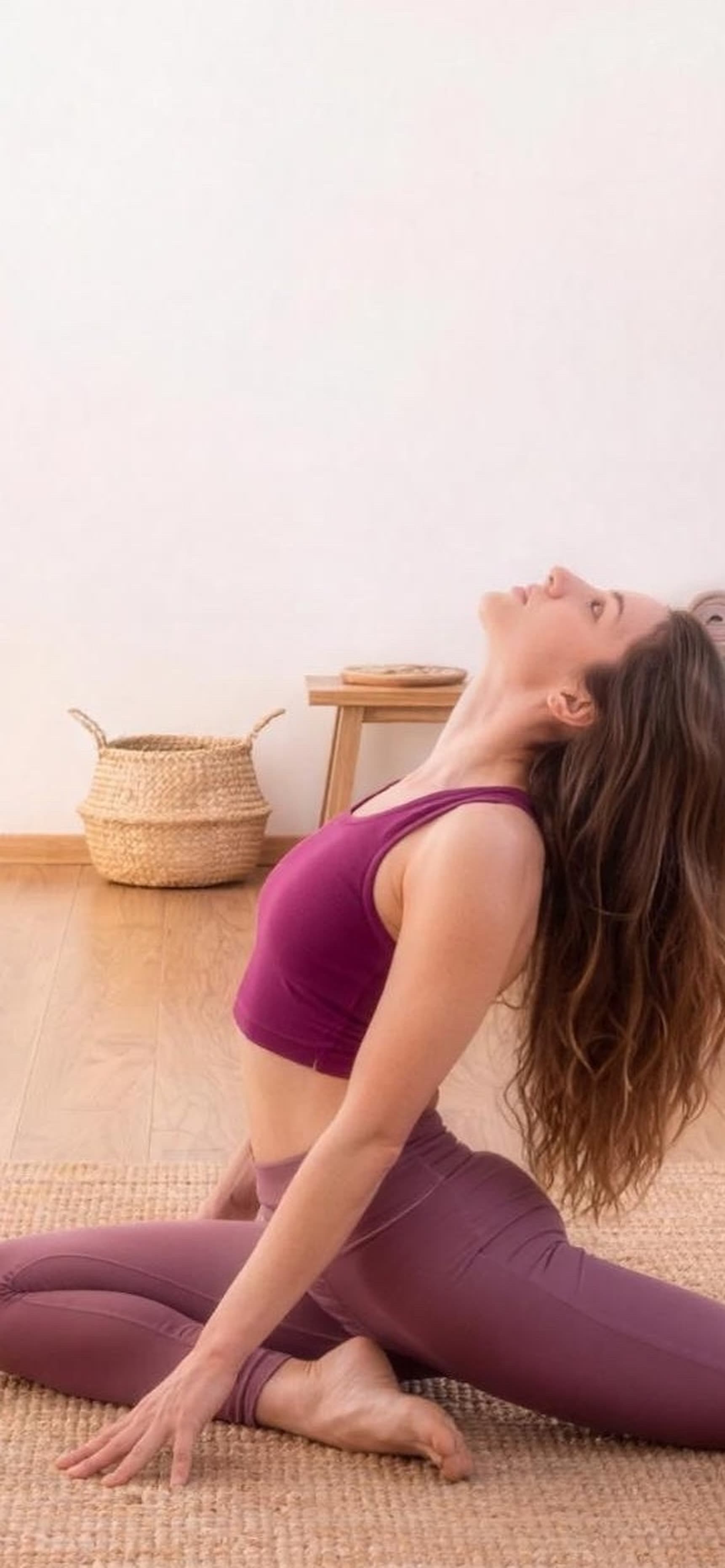 Laura Furlai in un elegante backbend nella shala luminosa di Sama Yoga, tra luce naturale, piante e pavimento in legno.